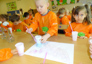 14 Dzieci kolorową pianę przekładają na biały karton tworząc obrazek
